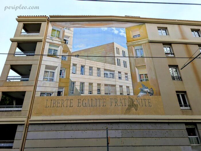 Trompe-l’œil monumental sur l’Avenue des Droits de l’Homme à Montpellier avec l’inscription « Liberté Égalité Fraternité » intégré à un parcours de Street art urbain
