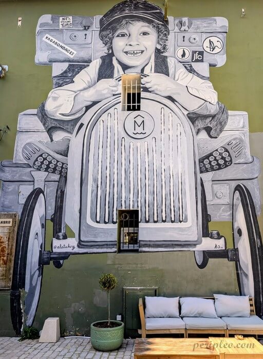 Immense fresque en noir et blanc de Alsticking représentant un enfant au volant d'une voiture vintage au Marché du Lez à Montpellier