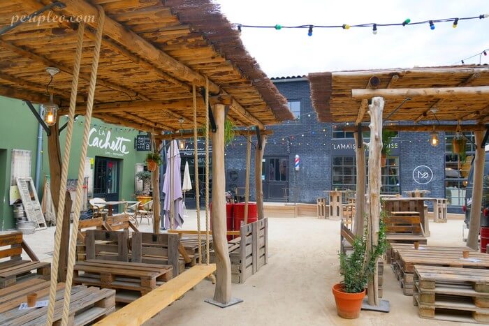 Terrasses en bois au Marché du Lez à Montpellier, ambiance guinguette avec restaurants et espaces conviviaux en plein air