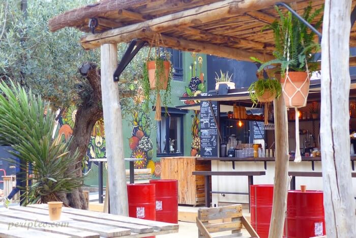 Food court au Marché du Lez à Montpellier, ambiance bohème avec street art, plantes suspendues et restauration en plein air