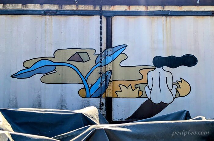 Fresque de street art minimaliste aux formes végétales sur une porte industrielle du Marché du Lez à Montpellier
