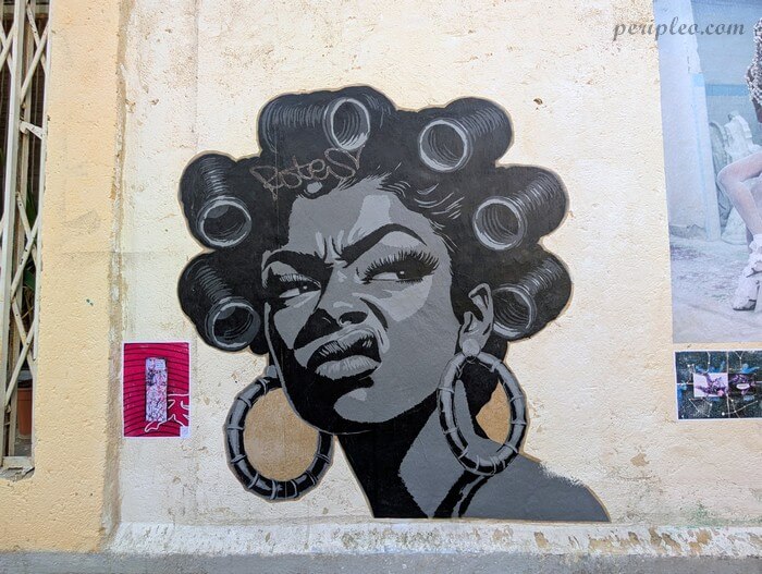 Street art Rue d'Alsace à Montpellier, portrait en noir et blanc d’une femme aux bigoudis réalisé sur un mur du Quartier Méditerranée