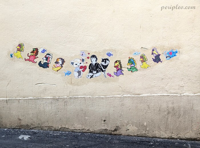 Street art Rue du Berger à Montpellier, frise de petits collages colorés mêlant créatures fantastiques, personnages de manga, animaux et poissons dans le centre historique nord