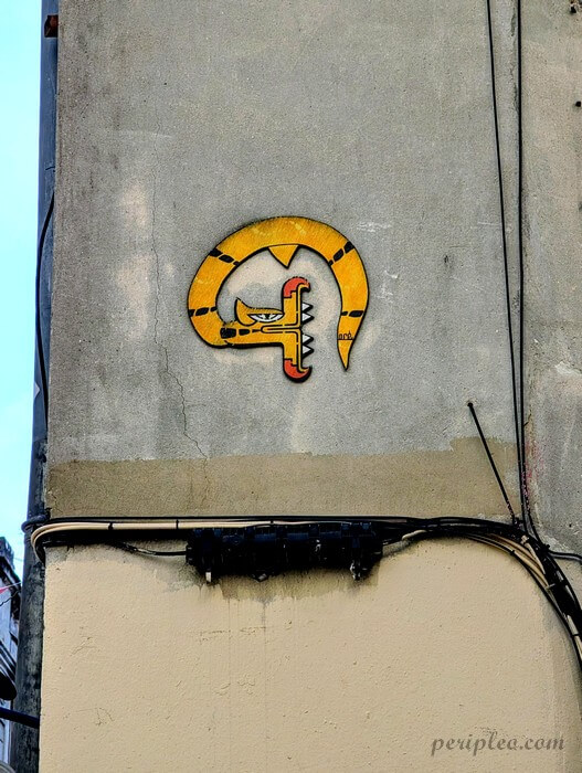 Petit street art coloré Rue de la Fontaine à Montpellier, dragon jaune signé ACE sur une façade du centre historique sud