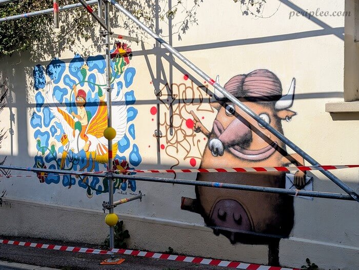 Street art Rue Laffite à Montpellier, fresque colorée de Mikael Moune mêlant personnage ailé et taureau fantastique sur un mur du Quartier Méditerranée