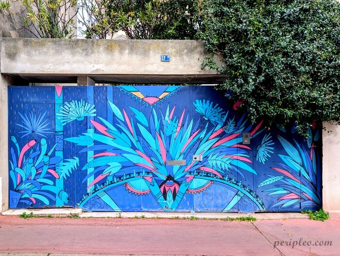 Street art Rue Lamartine à Montpellier, fresque végétale aux couleurs bleu et rose de Noon ornant un portail dans le Quartier Méditerranée