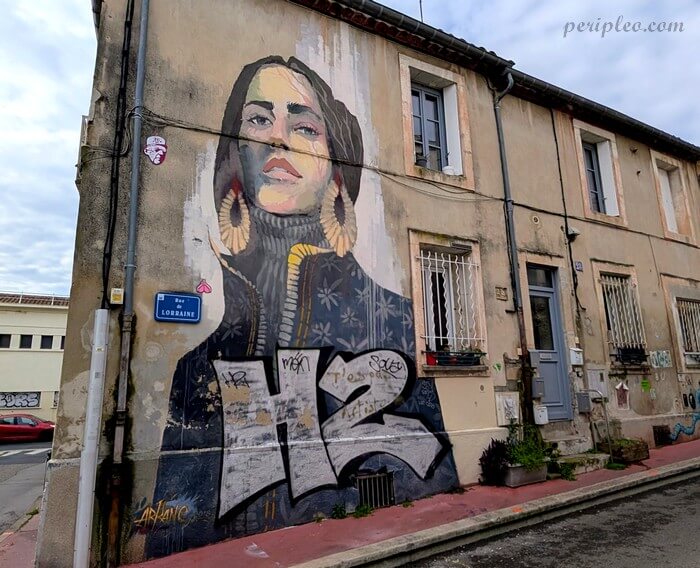 Street art Rue de Lorraine à Montpellier avec immense portrait féminin peint par Arkane sur une façade ancienne dans le Quartier Méditerranée de la ville