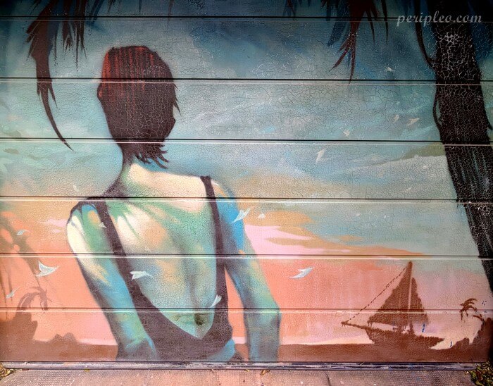 Street art Rue de Lorraine à Montpellier, fresque d'Arkane aux couleurs pastel représentant une silhouette face à la mer et à un voilier dans le Quartier Méditerranée