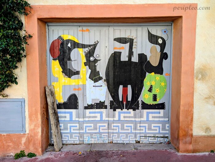 Œuvre de street art colorée Les Baigneurs du Clapas de Zohar Sanneh sur une porte de garage en bois dans la Rue Marie Muller dans le Quartier Méditerranée de Montpellier