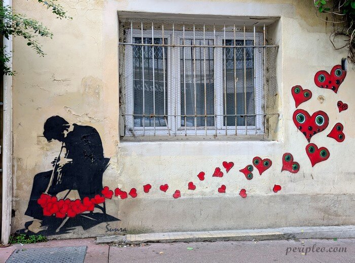 Street art Rue de la Méditerranée à Montpellier, pochoir romantique de Sunra et Oups représentant un musicien entourée de cœurs rouges sur un mur du Quartier Méditerranée