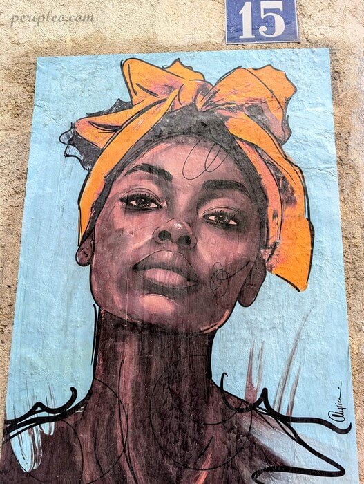 Street art Rue de la Méditerranée à Montpellier, portrait féminin au turban jaune réalisé en collage sur un mur du Quartier Méditerranée