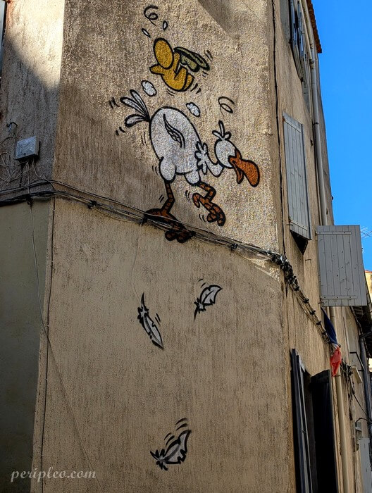Street art humoristique de Jace Rue du Plan de l’Olivier à Montpellier représentant un canard et un gouzou sur la façade d’un immeuble du centre historique nord