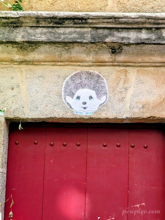 Street art Rue du Puits du Temple à Montpellier, collage de Crying Sailor au-dessus d’une porte rouge dans le centre historique sud