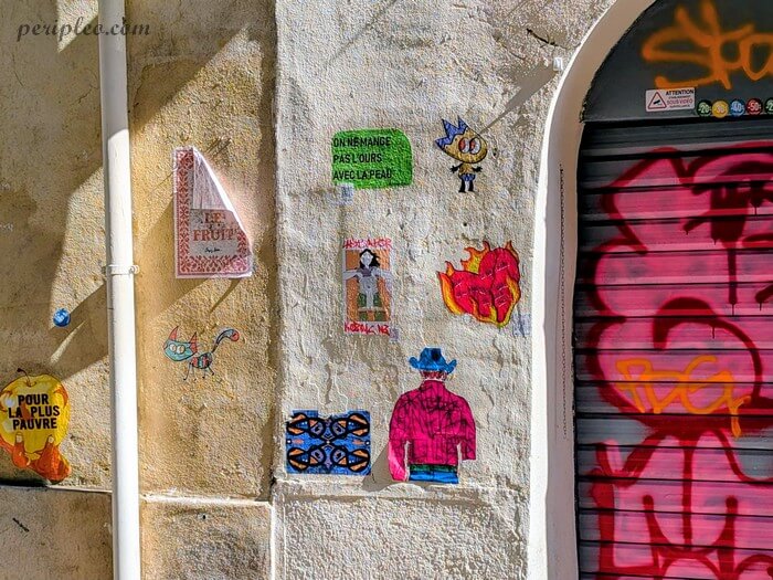 Street art Rue Roucher à Montpellier, accumulation de collages colorés et d’illustrations sur un mur du centre historique sud