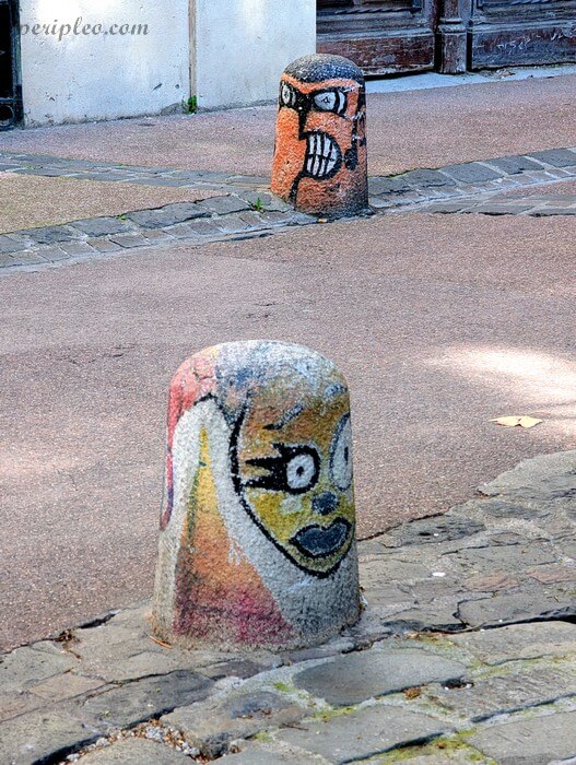 Street art insolite Rue Saint-Paul et Rue des Sœurs Noires à Montpellier, bornes urbaines peintes de visages colorés dans le centre historique sud