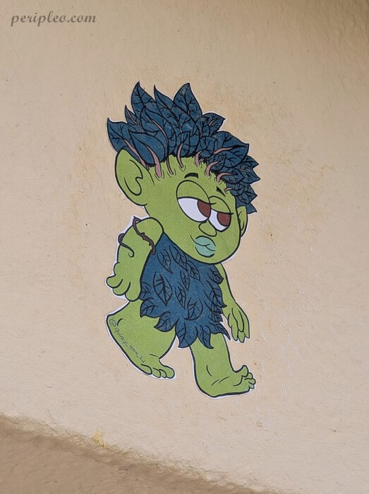 Street art Rue Voltaire à Montpellier, personnage vert aux feuilles bleues de l'illustrateur Quincy Gane dans le centre historique sud