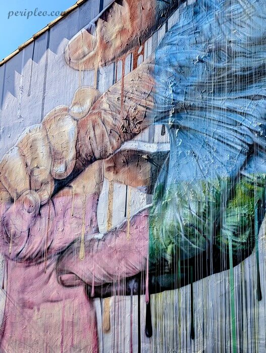 Street art Avenue de Toulouse à Montpellier, impressionnante fresque de Seno en style hyperréaliste représentant deux mains se rejoignant