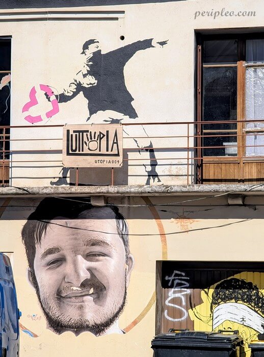 Graffiti pochoir sur façade d’immeuble Avenue de Toulouse à Montpellier : silhouette d’un homme en mouvement lançant un cœur rose, au-dessus d’une enseigne UTOPIA, avec portrait réaliste d’un visage masculin en bas de composition
