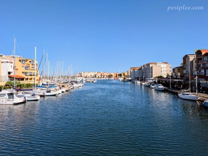Canal du Port de Gruissan bordé de bateaux et résidences dans l’Aude en Occitanie