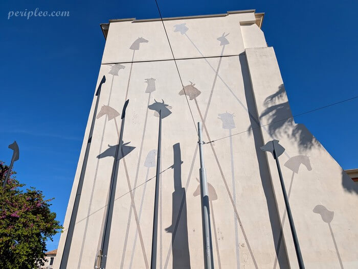 Street art Le Carnaval des Animaux près du Corum à Montpellier avec silhouettes d’animaux géantes sur une façade contemporaine