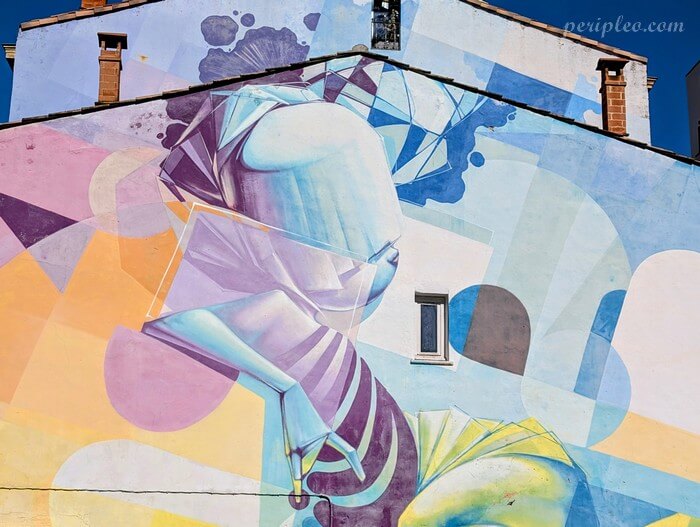 Street art Place Rondelet à Montpellier avec immense fresque contemporaine aux formes abstraites et couleurs pastel de Zest sur une façade urbaine