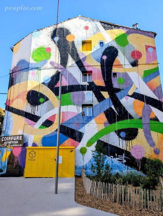 Street art Place Rondelet à Montpellier avec immense fresque abstraite multicolore de Mist sur une façade urbaine du centre-ville