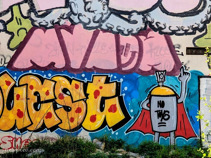 Fresque street art Rue Albert Leenhardt à Montpellier, graffitis colorés et personnage urbain dans une friche du quartier contemporain