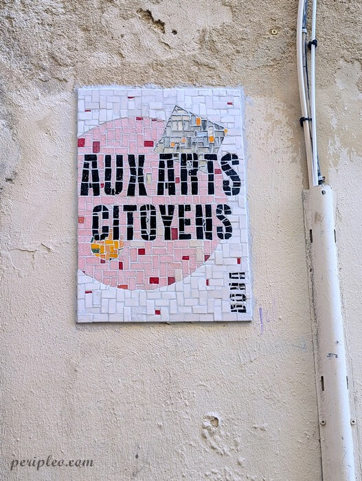 Street art Rue de l'École de la Pharmacie à Montpellier, mosaïque « Aux arts citoyens » mêlant typographie et silhouette architecturale dans le centre historique nord