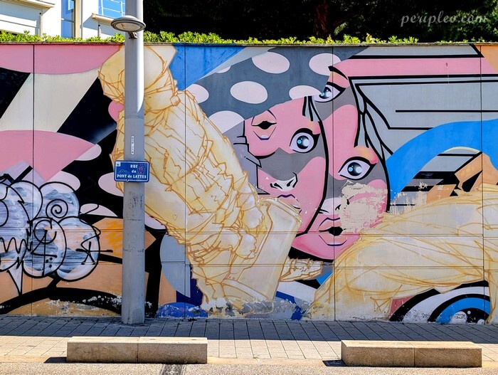 Street art Rue du Pont de Lattes à Montpellier, détail d’une fresque urbaine colorée représentant un visage féminin stylisé au bord des voies du tramway avec le soutien de la galerie Nicolas Xavier