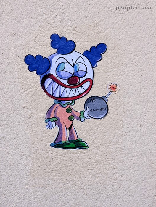Sticker de street art de l'illustrateur Quincy Gane Rue Rhin et Danube à Montpellier représentant un clown cartoon tenant une bombe dans le centre historique sud
