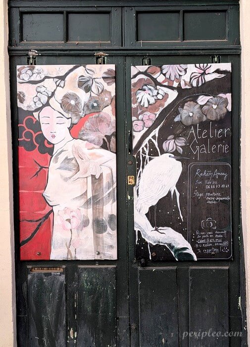Porte de l'atelier artistique de Rahem Ancey décorée d’une fresque poétique Rue Sainte-Ursule à Montpellier dans le centre historique nord