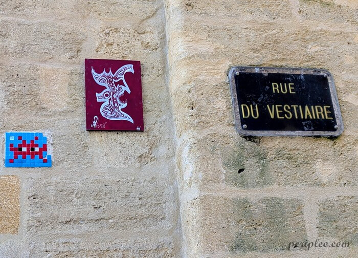 Street art Rue du Vestiaire à Montpellier, rencontre insolite entre une mosaïque inspirée du célèbre Space Invader et un petit collage graphique aux allures de créature fantastique dans le centre historique nord