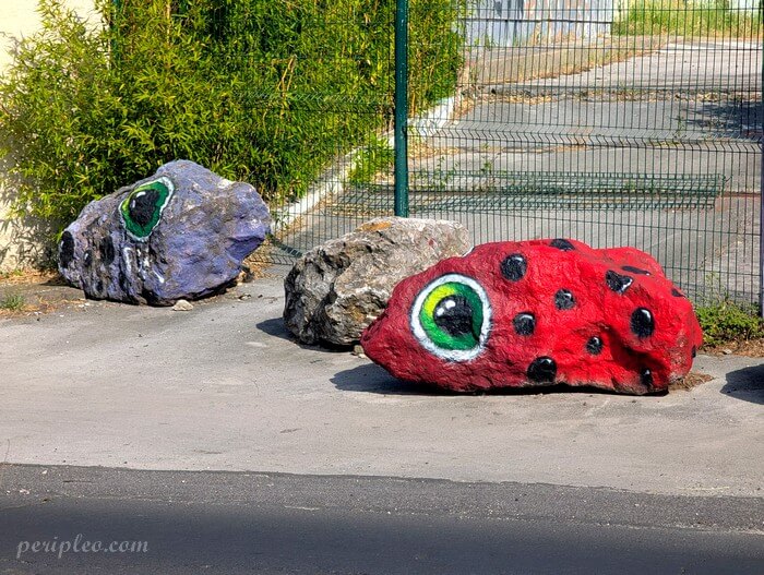 Street art Avenue des Moulins à Montpellier, série de rochers peints transformés en créatures fantastiques grâce à de grands yeux expressifs et des couleurs vives