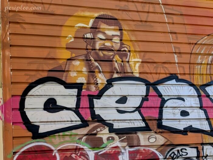 Street art au Gymnase Louis Nègre à Montpellier, détail d'une fresque représentant un homme en train de téléphoner, peint dans un style semi-réaliste aux tons chauds
