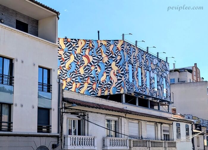 Street art Quai des Tanneurs à Montpellier, immense fresque géométrique aux motifs entrelacés en noir, blanc, bleu et ocre
