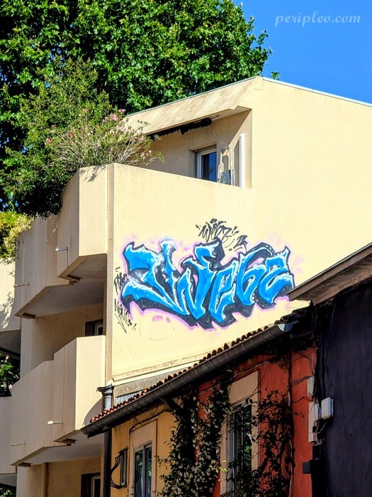 Graffiti street art Rue Desmazes à Montpellier, lettrage bleu peint sur une façade du centre historique sud