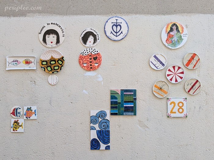 Street art Rue du Général Vincent à Montpellier, compositions en céramique de Sophie Massault et mosaïques d'Erica Stefani Frammenti sur un mur du centre historique sud
