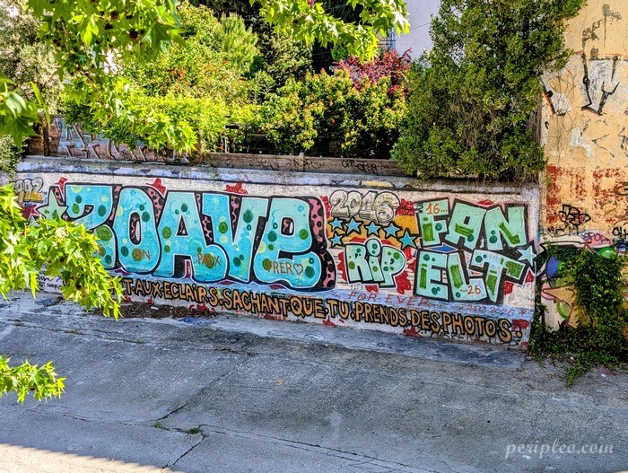 Fresque de street art colorée le long du canal du Verdanson à Montpellier, avec graffitis et messages peints sur un mur en bord de chemin