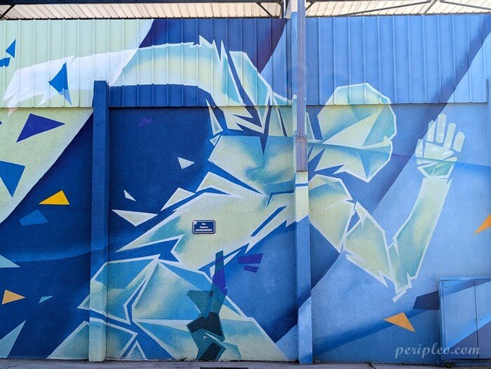 Street art au Stade Philippidès à Montpellier, détail d'une fresque monumentale du collectif Bombing Colors représentant un athlète stylisé aux formes géométriques