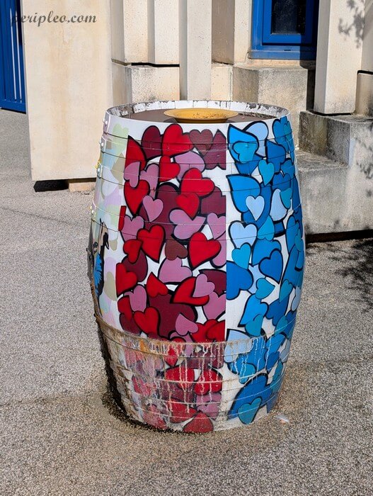 Street art au Château d'Alco à Montpellier, œuvre de Sunra réalisée sur un tonneau urbain entièrement recouvert de cœurs rouges, roses, blancs et bleus