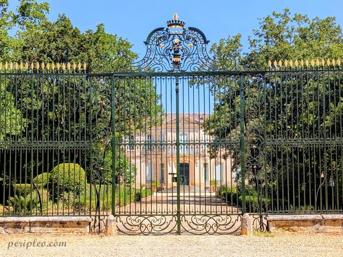 Grille en fer forgé du Château de l'Engarran à Lavérune avec le château en arrière-plan
