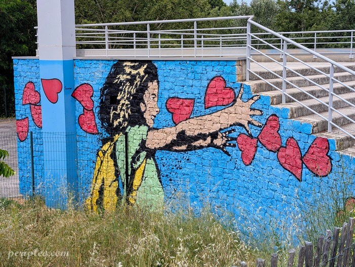 Street art au Parc des Berges du Lez à Montpellier, œuvre de Sunra représentant une fillette tendant les bras vers une envolée de cœurs rouges