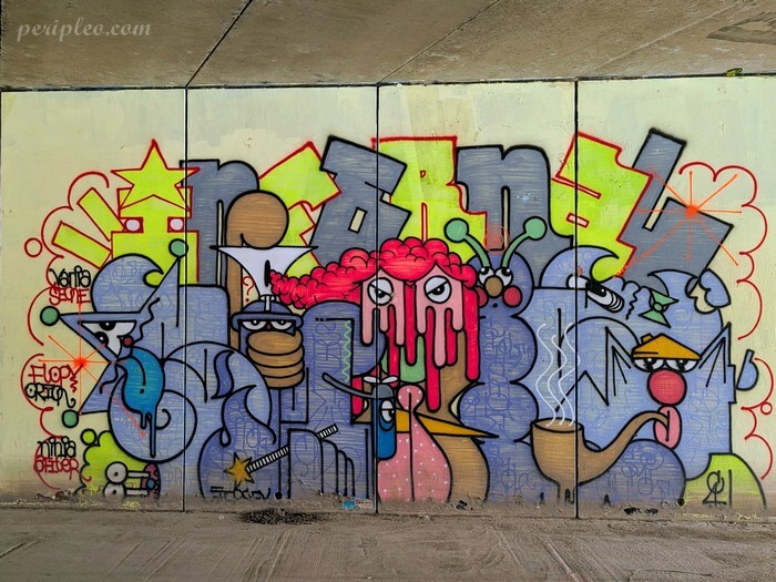 Street art Quai du Verdanson à Montpellier, grande fresque sous le pont mêlant personnages décalés, formes abstraites et lettrages graffiti