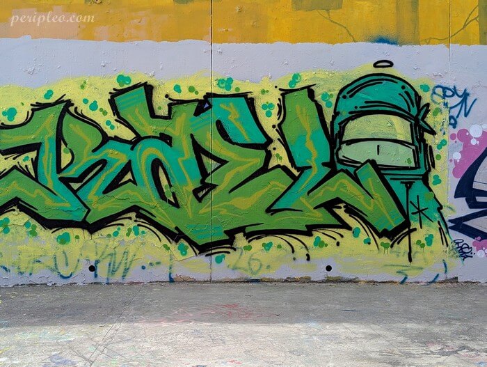 Street art Quai du Verdanson à Montpellier, graffiti aux nuances de vert mêlant lettrages anguleux et casque stylisé