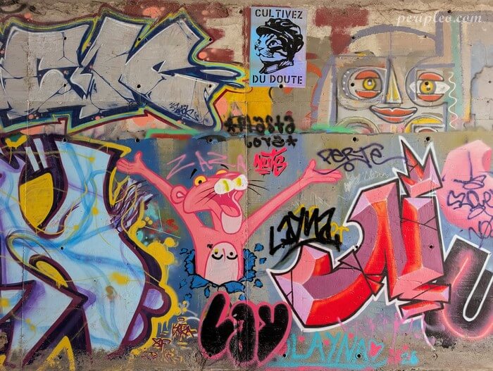 Mur couvert de graffitis colorés et de personnages emblématiques au Quai du Verdanson, spot incontournable du Street art à Montpellier