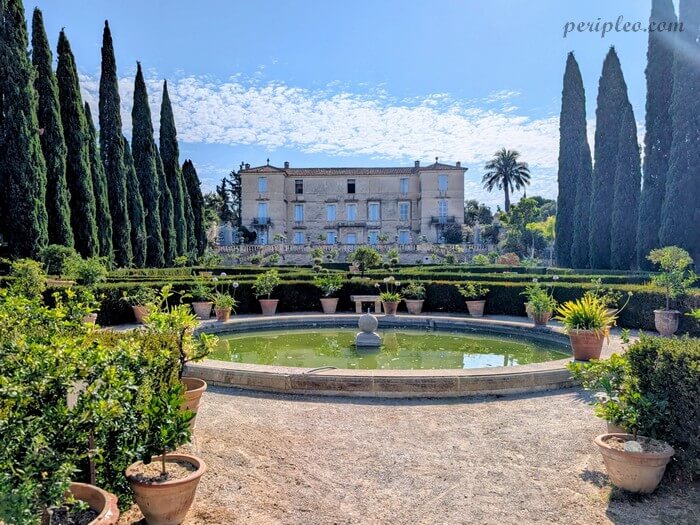 Jardins à la française du Château de Flaugergues à Montpellier avec bassin circulaire, cyprès et façade du château en arrière-plan