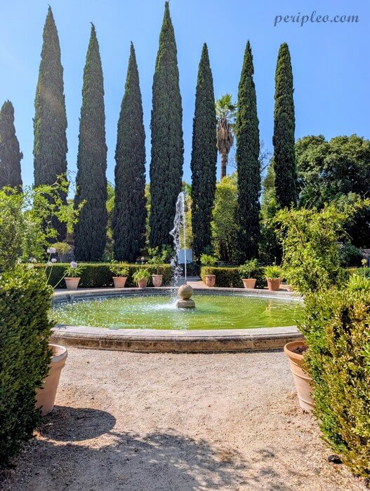 Bassin avec fontaine dans les jardins à la française du Château de Flaugergues à Montpellier, bordé de majestueux cyprès