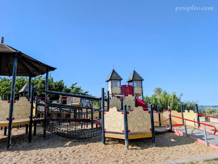 Grande aire de jeux avec château fort au Parc du Mas Rouge à Pérols, espace ludique pour les enfants au bord de l’étang du Méjean